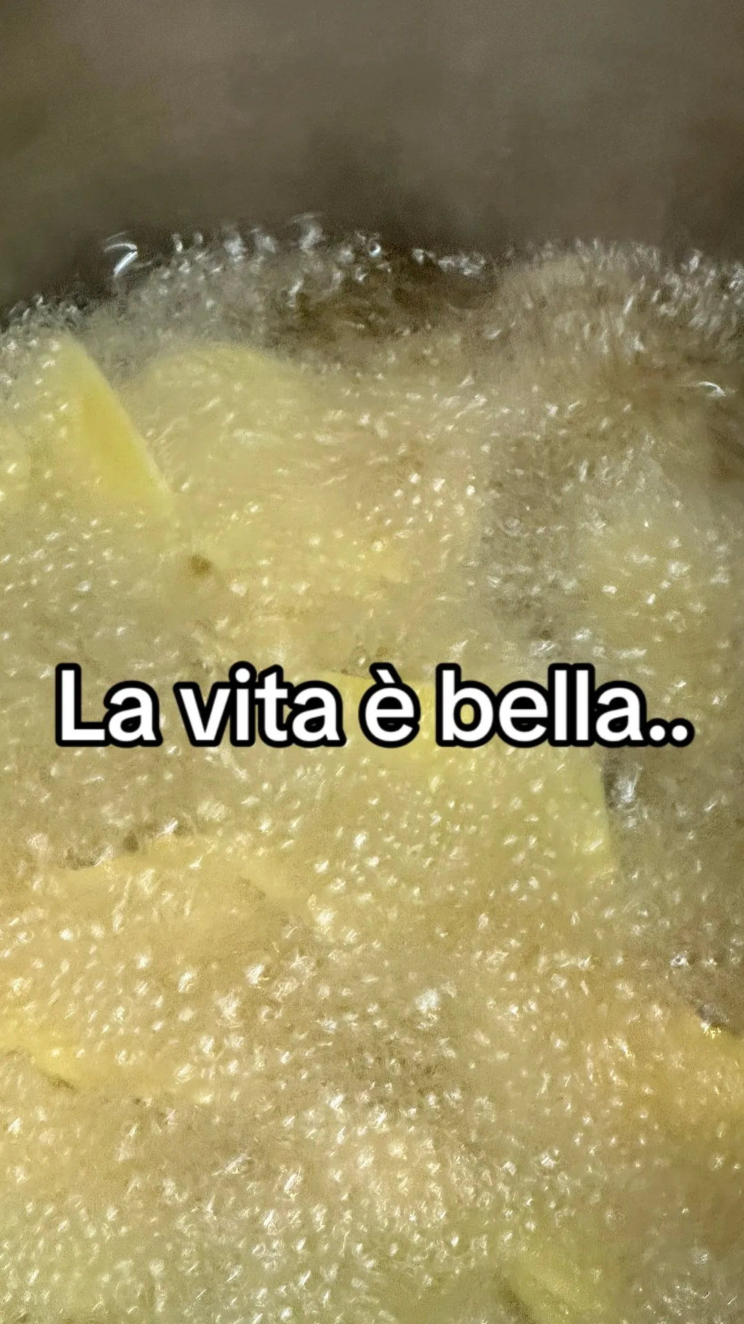 Patatine che friggono nell'olio, con la scritta La vita è bella